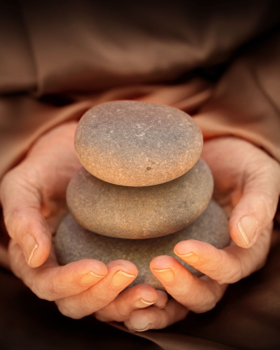 karmic purpose hands holding stones