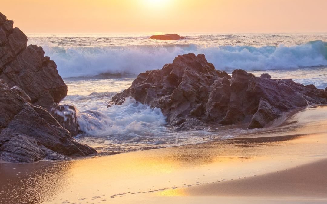 sun over beach rocks